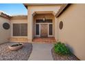Close-up of the entrance showcasing a wooden front door with decorative accents and a cozy porch at 2449 E Desert Flower Ln, Phoenix, AZ 85048