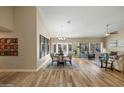 An open-concept living area featuring hardwood floors, a dining table and views of the backyard at 2449 E Desert Flower Ln, Phoenix, AZ 85048