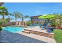 Stunning backyard oasis featuring a sparkling pool, spa, stone accents, and comfortable lounge seating at 2468 W Dapple Gray Ct, San Tan Valley, AZ 85144