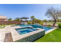 Luxurious backyard oasis featuring a pool, spa, and outdoor kitchen area at 29051 N Shannon Dr, San Tan Valley, AZ 85143
