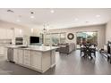 Open-concept kitchen with a large island, stainless steel appliances, and adjacent dining area at 3269 E Ironside Ln, Gilbert, AZ 85298