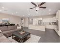Open-concept living space with tile flooring, a large sofa, and an eat-in kitchen area at 3269 E Ironside Ln, Gilbert, AZ 85298