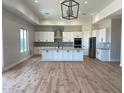 Spacious kitchen featuring white cabinets, a large center island, stainless steel appliances, and hardwood floors at 34889 N 3Rd St, Phoenix, AZ 85086