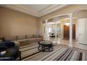 Bright living room with neutral walls, a striped rug, and architectural columns leading to the dining area at 3816 E El Sendero Rd, Cave Creek, AZ 85331