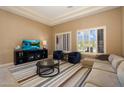 Comfortable living room featuring a sectional sofa, entertainment center, and bright, shuttered windows at 3816 E El Sendero Rd, Cave Creek, AZ 85331
