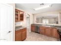 Well-lit kitchen featuring wood cabinets, stainless steel appliances, and tile flooring at 3994 E Maplewood St, Gilbert, AZ 85297