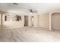 Spacious living room with neutral walls, a ceiling fan, and an open view into the kitchen at 3994 E Maplewood St, Gilbert, AZ 85297