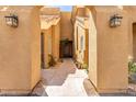 A landscaped walkway leading to a condominium unit with stone, plants, and decorative lights on the walls at 4644 N 22Nd St # 1137, Phoenix, AZ 85016