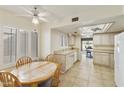 Bright kitchen with tile flooring, white cabinets, and a ceiling fan overlooking a breakfast nook at 562 S Palo Verde Way, Mesa, AZ 85208