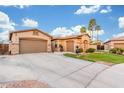Southwest home with a three car garage and expansive driveway with palm trees at 5639 S Four Peaks Pl, Chandler, AZ 85249
