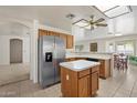 Bright kitchen features stainless steel refrigerator and center island with adjacent breakfast nook at 63 W Los Arboles Dr, Tempe, AZ 85284