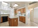 Bright eat-in kitchen featuring a center island, white appliances, and lots of cabinet space at 63 W Los Arboles Dr, Tempe, AZ 85284