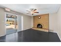 Inviting living room with a brick fireplace, ceiling fan, and sliding door access to the pool at 742 E Garnet Ave, Mesa, AZ 85204