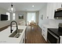 Open-concept kitchen flows into the living area with wood floors and natural light at 7531 E Billings St # 123, Mesa, AZ 85207