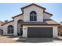 Charming two-story home with an arched entry, tile roof, desert landscaping, and a two car garage at 7869 W Market St, Glendale, AZ 85303