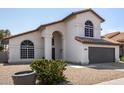Charming two-story home with an arched entry, tile roof, desert landscaping, and a two car garage at 7869 W Market St, Glendale, AZ 85303