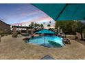 Resort-style backyard featuring a sparkling pool, rock waterfall, and outdoor kitchen perfect for entertaining at 890 W Zion Pl, Chandler, AZ 85248
