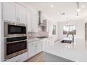 Modern kitchen featuring white cabinetry, stainless steel appliances, and a large center island at 11660 W Luxton Ln, Avondale, AZ 85323