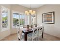 Bright dining room with a modern chandelier and views of the greenery at 12425 W Jefferson St, Avondale, AZ 85323