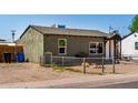 A street view of the grey painted home with gravel landscape and chain link fence at 1424 S Bonarden Ln, Tempe, AZ 85281
