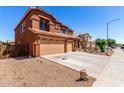 Side view of a desert-landscaped home showing a three-car garage and gravel yard at 1690 E Desert Breeze Ct, Casa Grande, AZ 85122