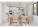 Open-concept dining area with a wooden table, chairs, and a view into the modern kitchen at 20309 W Roma Ave, Buckeye, AZ 85396