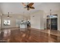 Open-concept living room with wood floors, vaulted ceilings, and a view to the kitchen and backyard at 2882 N 155Th Dr, Goodyear, AZ 85395