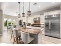Open kitchen boasts stainless steel appliances, granite counters, pendant lighting, and an island with seating at 3751 E Zachary Dr, Phoenix, AZ 85050