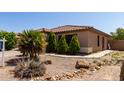 Well-maintained front yard with desert landscaping, including rocks and small trees at 42311 W Bunker Dr, Maricopa, AZ 85138