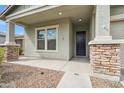 Charming front porch features stone pillars and a modern black door, enhancing curb appeal at 460 W Glacier Bay Dr, San Tan Valley, AZ 85140