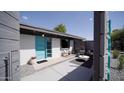 Charming front yard with desert landscaping, light gray patio, and a vibrant turquoise door at 5809 N 10Th Pl, Phoenix, AZ 85014