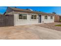 Charming single-story home with gray brick, concrete driveway, and xeriscaped front yard at 6823 W Coolidge St, Phoenix, AZ 85033