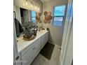 Stylish bathroom featuring a marble countertop, white cabinets, and decorative wall art at 905 S 108Th Ave, Avondale, AZ 85323
