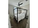 Contemporary bedroom showcasing a black canopy bed with white bedding and a modern ceiling fan at 905 S 108Th Ave, Avondale, AZ 85323