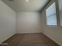 Bright bedroom featuring neutral carpet, a window and fresh white paint at 9543 W Parkway Dr, Tolleson, AZ 85353