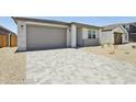 Inviting single-story home showcasing a spacious driveway, two-car garage and desert-style landscaping at 9543 W Parkway Dr, Tolleson, AZ 85353