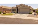 Single-story home features a desert landscape, circular grassy area and a two-car garage at 10621 W Pima St, Tolleson, AZ 85353