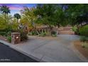 Spacious driveway leading to a well-maintained home with mature trees and manicured landscaping at 11821 S Tuzigoot Ct, Phoenix, AZ 85044