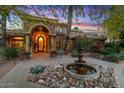 Inviting home featuring a beautiful water fountain, stone archway, and lush landscaping at 11821 S Tuzigoot Ct, Phoenix, AZ 85044