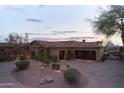 Stately home featuring a stone exterior, well-manicured landscaping, and a circular driveway at 12711 N 117Th St, Scottsdale, AZ 85259