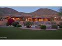 Spacious home exterior with a lush lawn, pool, and meticulously landscaped grounds at 12711 N 117Th St, Scottsdale, AZ 85259