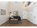Cozy living room featuring high ceilings, wood-look floors, and stylish decor at 14095 W Larkspur Dr, Surprise, AZ 85379