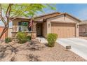 Attractive home featuring stone accents, neat landscaping, and a welcoming entryway with a charming front door at 14166 W Valentine St, Surprise, AZ 85379