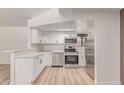 Modern kitchen with stainless steel appliances, white cabinets, light wood floors, and stylish countertops at 16402 N 31St St # 232, Phoenix, AZ 85032