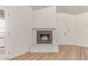 Bright living room featuring fireplace, light wood floors, and an entrance to the outdoor patio at 16402 N 31St St # 232, Phoenix, AZ 85032