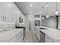 Modern kitchen with white cabinetry, stainless steel appliances, subway tile backsplash, and a large central island at 16945 W Vernon Ave, Goodyear, AZ 85395