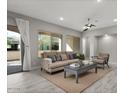 Bright living room featuring neutral tones, stylish furniture, contemporary ceiling fan, and access to the outdoor space at 16945 W Vernon Ave, Goodyear, AZ 85395