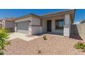 A single-story home showcasing desert landscaping and a neutral color palette at 16996 W Fetlock Trl, Surprise, AZ 85387