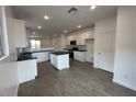 Bright, open kitchen featuring white cabinets, a center island with breakfast bar, and stainless steel appliances at 16996 W Fetlock Trl, Surprise, AZ 85387
