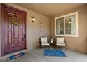 Welcoming front porch featuring neutral furniture, a charming wreath, and a cozy rug, inviting guests into the home at 18585 E Ryan Rd, Queen Creek, AZ 85142